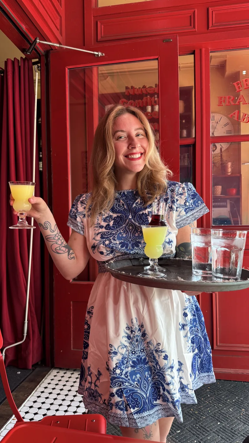 A server carrying drinks to the patio at Paris Crêpes Café, Niagara Falls