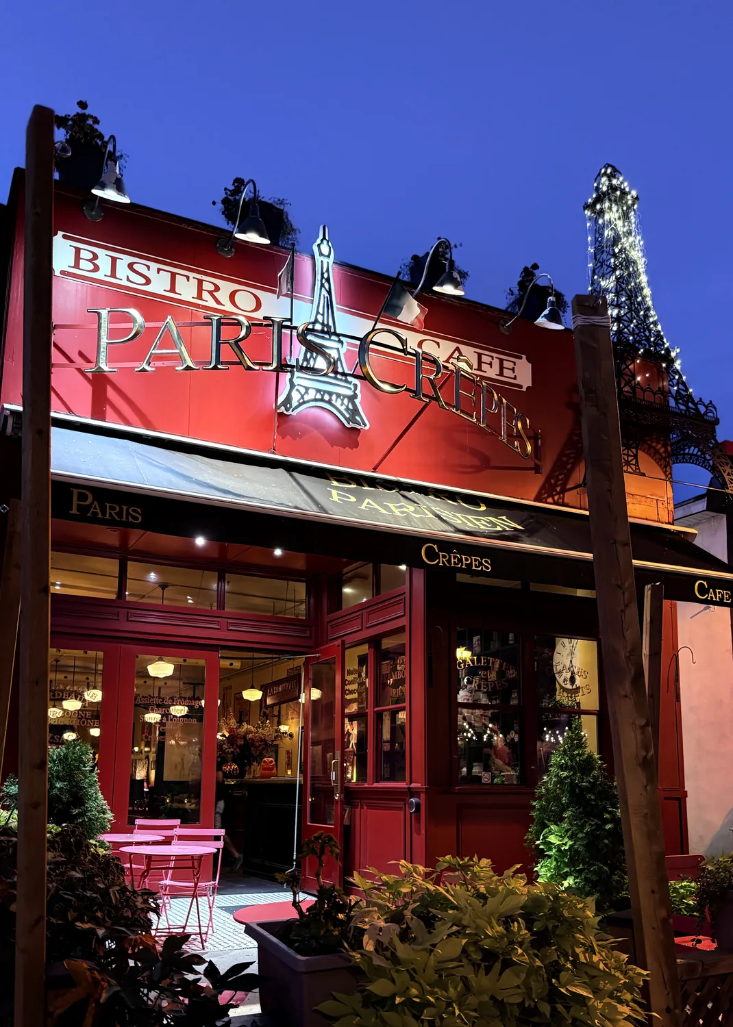 Paris Crêpes Café lit up at dusk on Queen Street, Niagara Falls — two minutes from the new concert hall